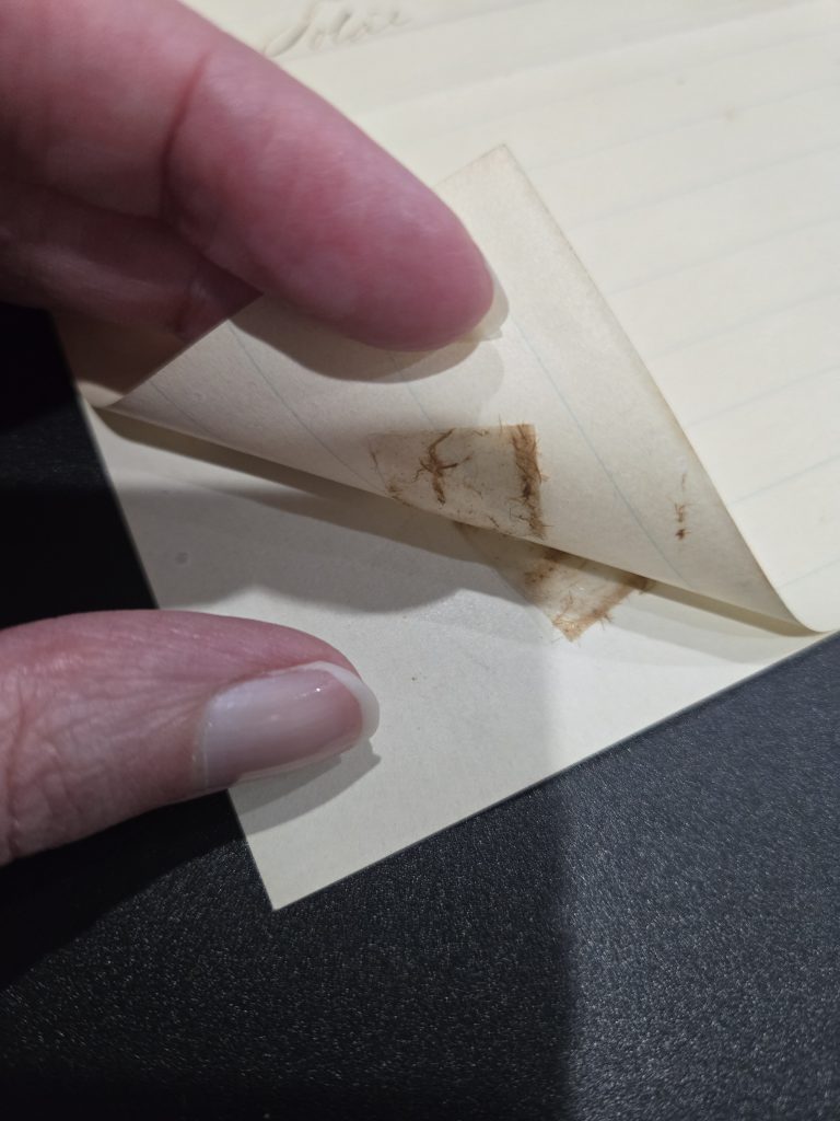 Two pieces of rolled up Scotch tape on the back of this historic document were stuck together when it was folded in half. It discolored the original paper and also left behind a sticky residue.